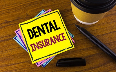 Dental insurance written on yellow post it note