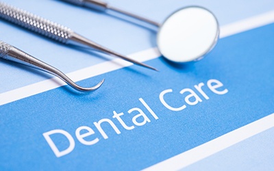 Dental care written on blue paper surrounded by dental tools