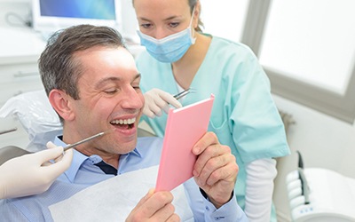 Man in dental chair looking at smile