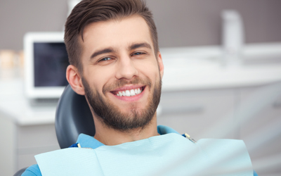 man sitting in dental chair smiling