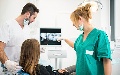 patient and dentist looking at x-rays