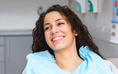 Woman smiling wearing dental bib